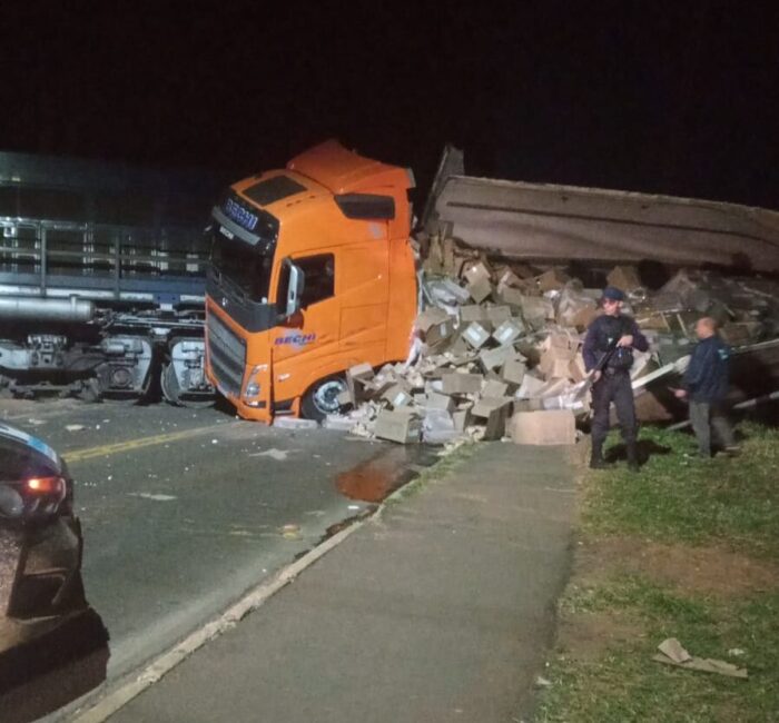 COLISÃO ENTRE CAMINHÃO E TREM BLOQUEIA RUA NO BAIRRO NEVES, EM PONTA GROSSA — CARGA DE CONGELADOS CAI NA PISTA